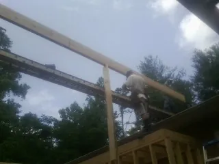Carpenter setting a ridge beam over a new addition frame — Ice Dam Removal by Roofing Brothers in Stayton
