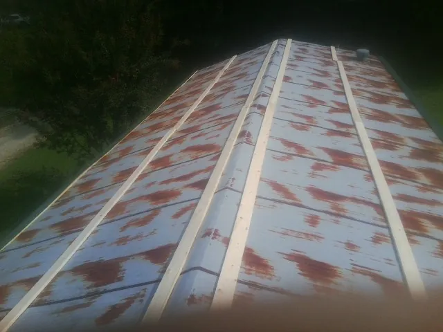 Rusted metal roof panels with new wood purlins before replacement — Storm Damage Roof Repair in Stayton by Roofing Brothers