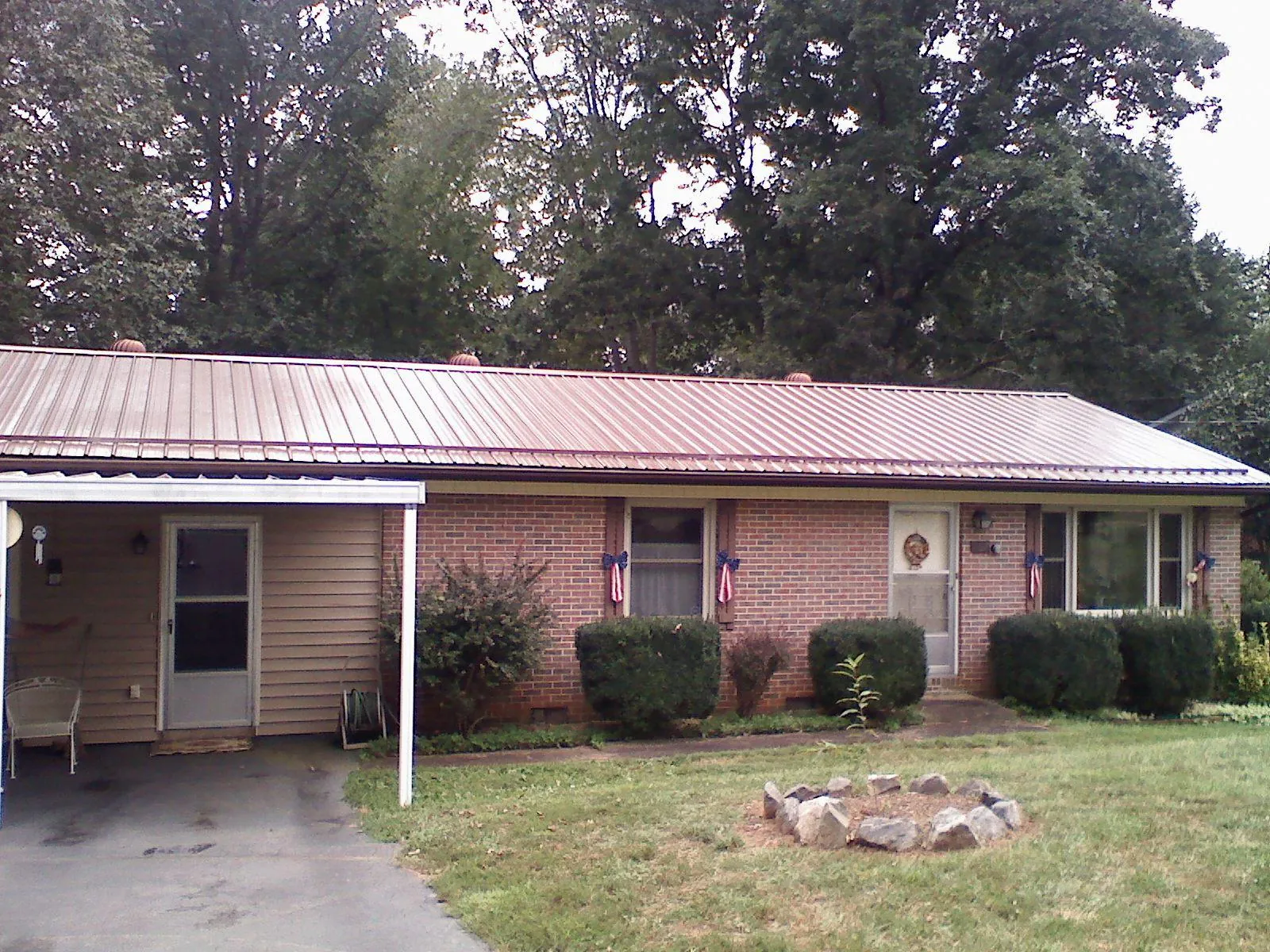 Bronze metal roof and carport on a brick ranch home — Roof Repair work by our crew in Stayton